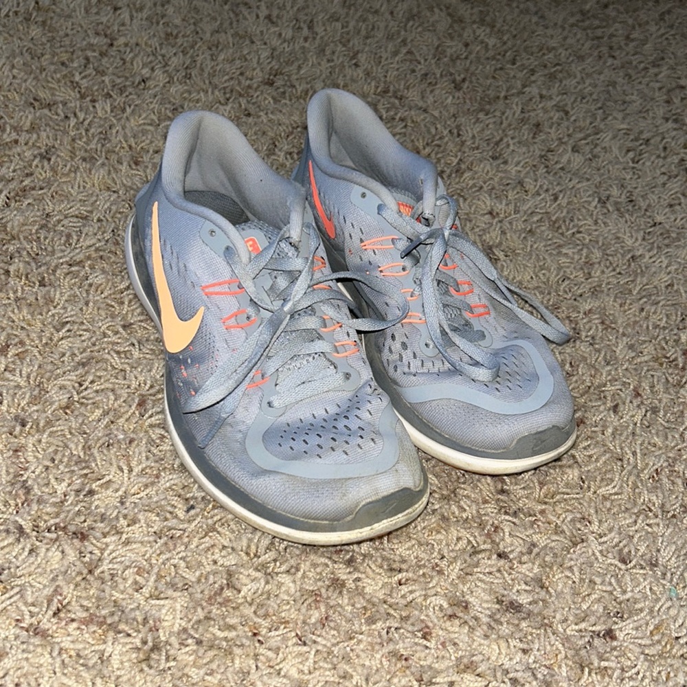 Grey and pink/orange Nike running shoes.